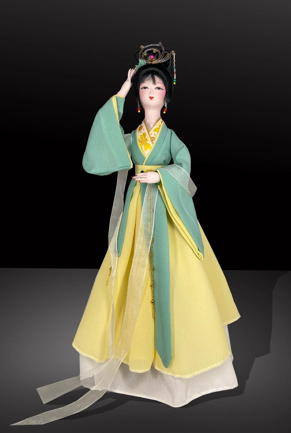 Traditional silk figurine in flowing green and yellow costume