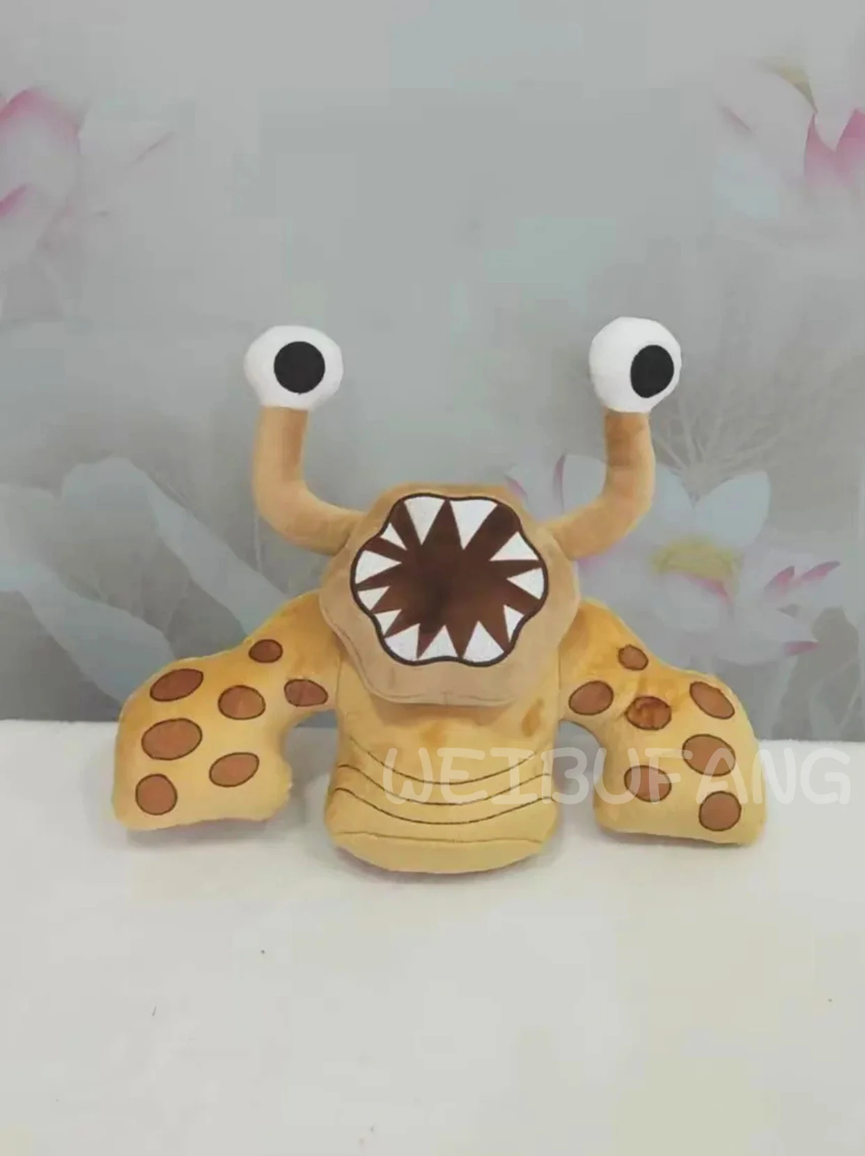 A spotted golden monster with raised eyes and a toothy grin.