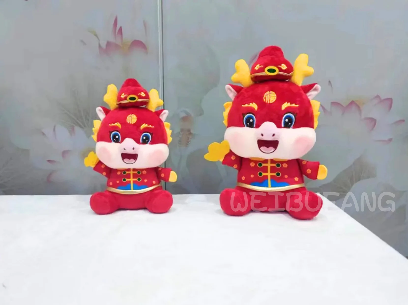 Two red festive dragon plush characters in coordinated outfits