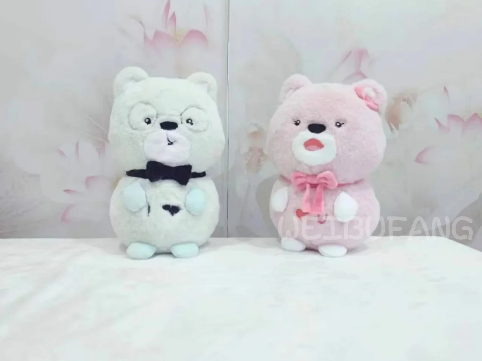 White and pink animal plush toys with coordinated bow details.