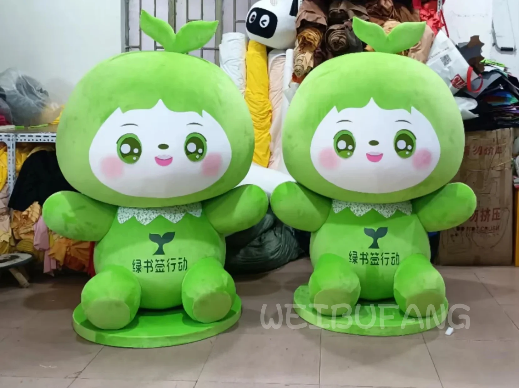 Two green plush characters with matching outfits