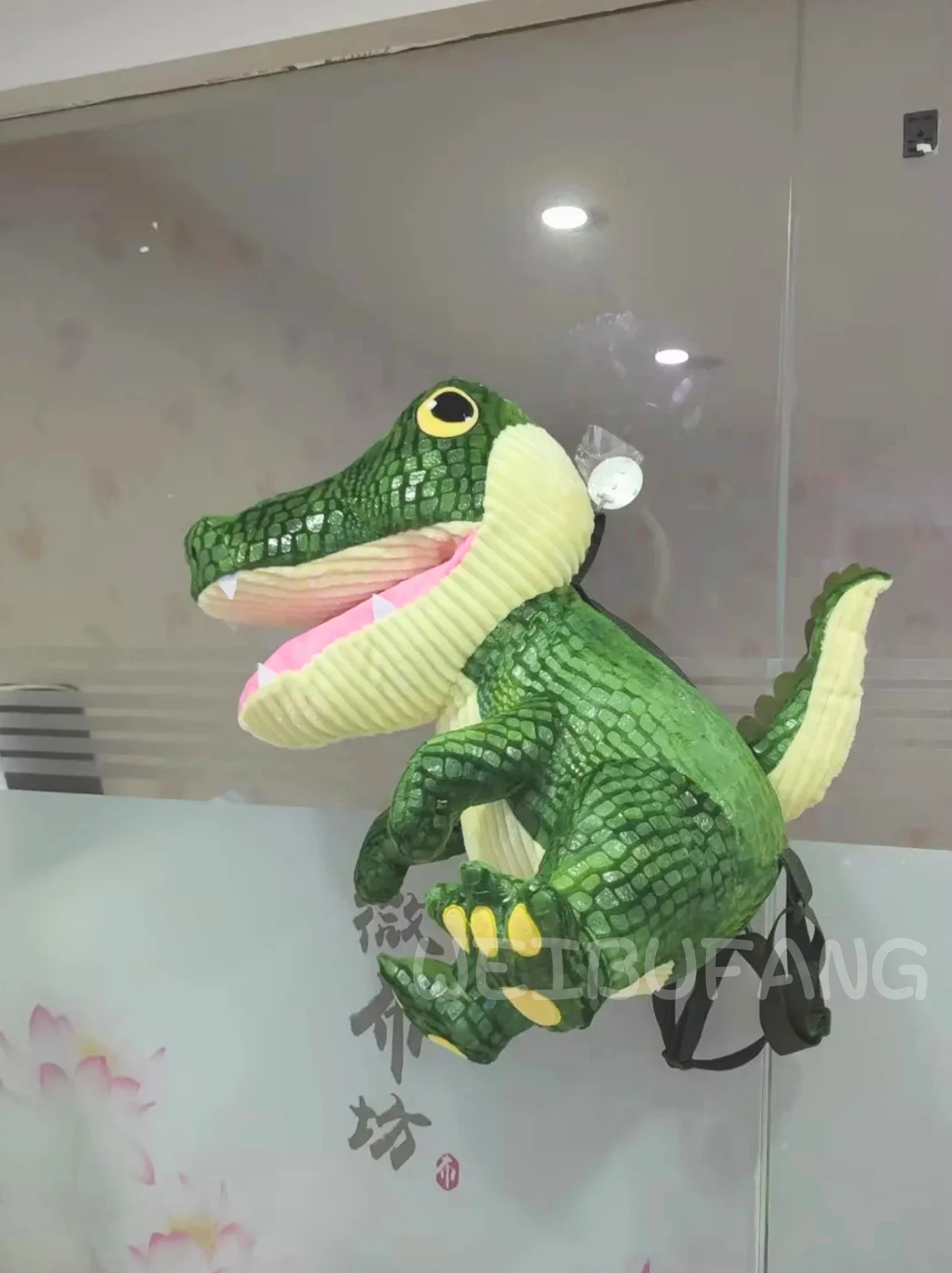 A green crocodile character with a broad open mouth and dimensional teeth.